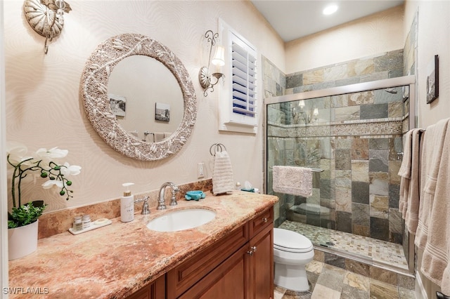 bathroom with walk in shower, vanity, and toilet