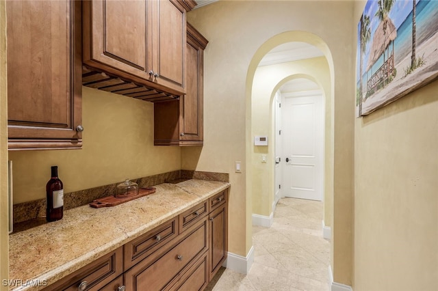 interior space featuring light stone counters and ornamental molding