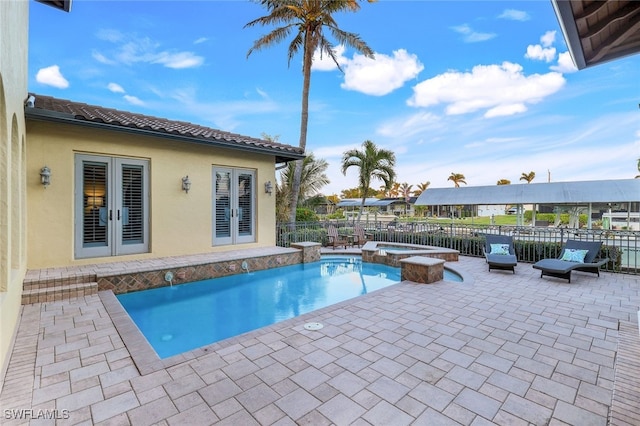 view of swimming pool with a patio area, an in ground hot tub, and french doors