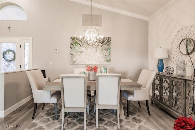 dining space with wood-type flooring, crown molding, a wealth of natural light, and a chandelier