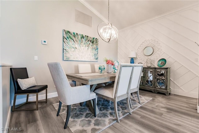 dining room with a chandelier, hardwood / wood-style flooring, and ornamental molding