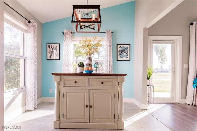 interior space featuring plenty of natural light, lofted ceiling, and decorative light fixtures