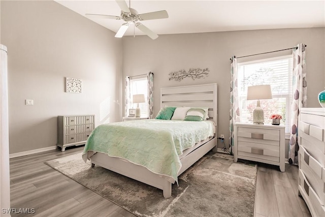 bedroom featuring ceiling fan, dark hardwood / wood-style flooring, and multiple windows