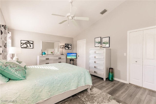 bedroom with hardwood / wood-style floors, vaulted ceiling, and ceiling fan