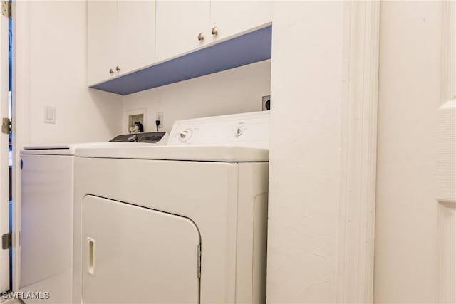 washroom featuring cabinets and washer and dryer