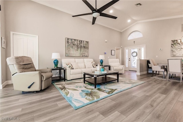 living room with ceiling fan, light hardwood / wood-style floors, ornamental molding, and high vaulted ceiling