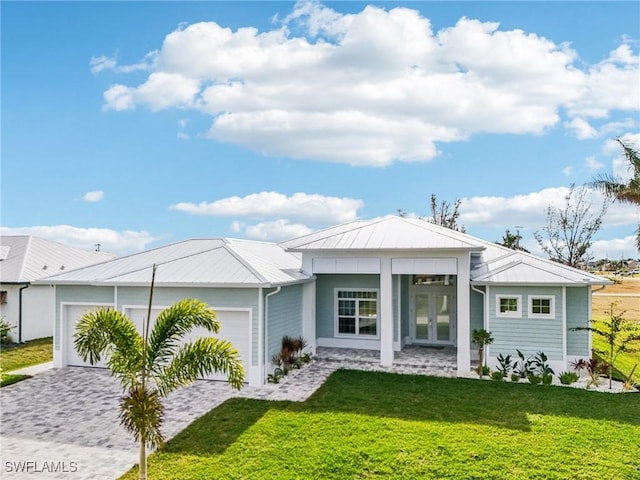 view of front of home with french doors, a front yard, and a garage