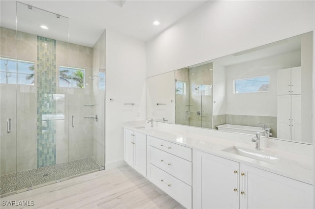 bathroom featuring hardwood / wood-style flooring, vanity, shower with separate bathtub, and a wealth of natural light