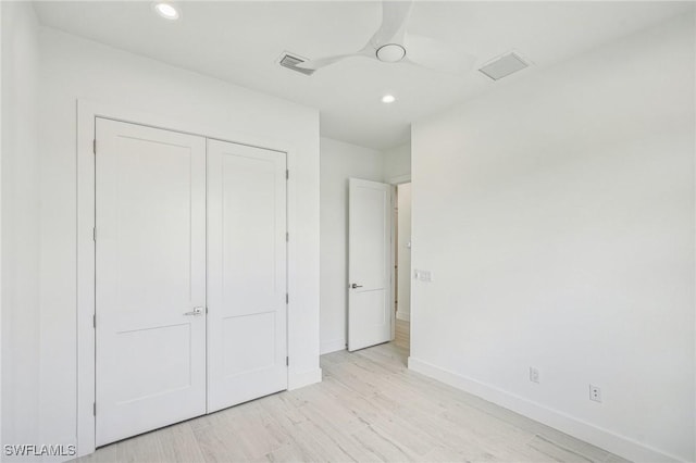 unfurnished bedroom featuring a closet, light hardwood / wood-style floors, and ceiling fan