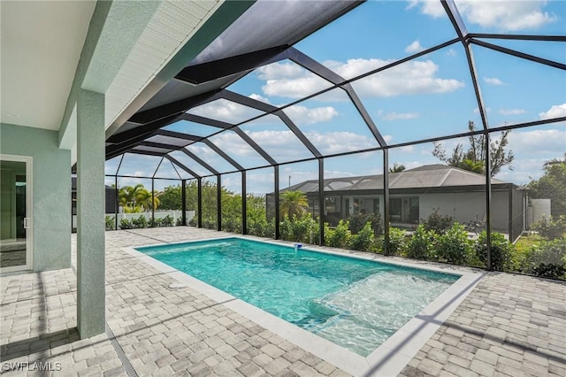 view of pool with a patio and glass enclosure