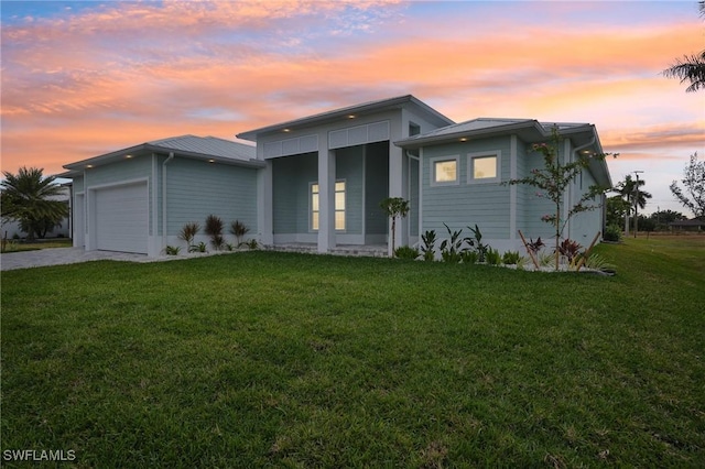 view of front of house featuring a garage and a lawn