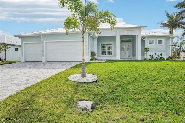 view of front of home featuring french doors, a front yard, and a garage