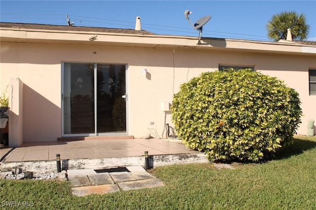 rear view of property featuring a patio area and a lawn