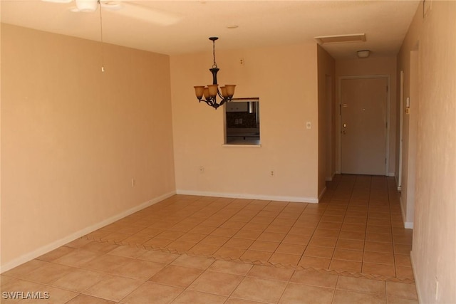 spare room with light tile patterned floors and an inviting chandelier