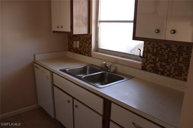 kitchen with dishwasher, sink, light tile patterned floors, backsplash, and white cabinets