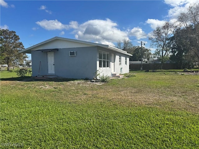 view of home's exterior with a wall mounted AC and a yard