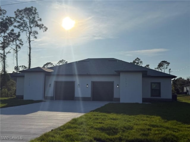 view of front of house with a garage, a front yard, concrete driveway, and stucco siding