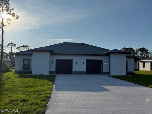 view of front of home with a garage, stucco siding, driveway, and a front yard