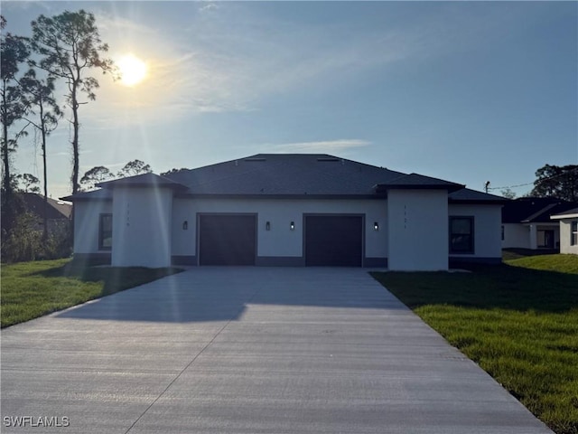 single story home featuring concrete driveway, a front lawn, an attached garage, and stucco siding