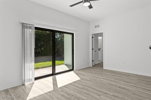 unfurnished room featuring baseboards, visible vents, and wood finished floors