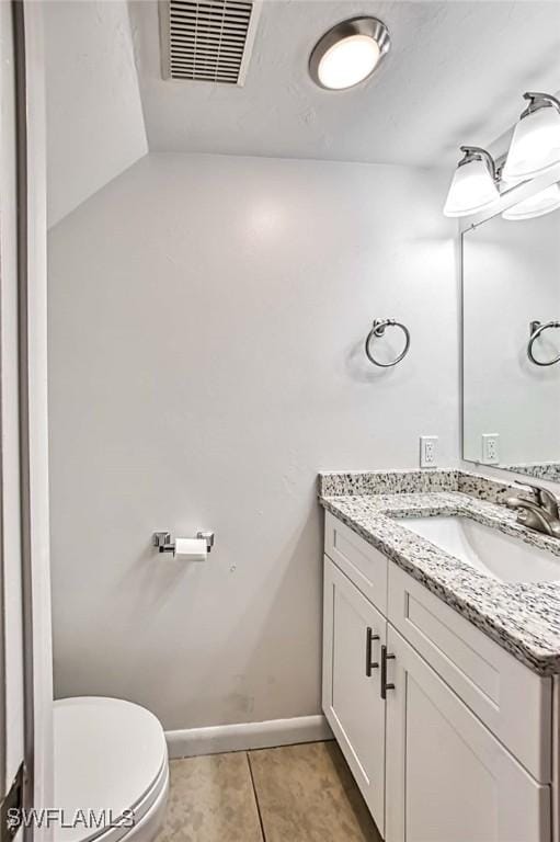 bathroom featuring tile patterned flooring, vanity, and toilet