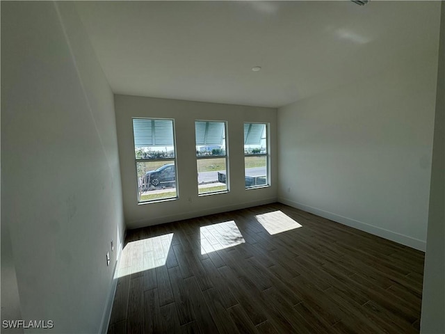 empty room with dark hardwood / wood-style flooring