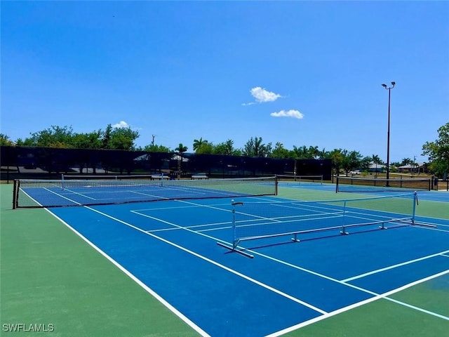 view of tennis court with basketball hoop