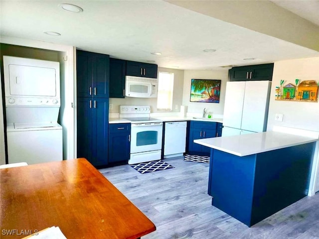 kitchen featuring blue cabinetry, sink, white appliances, stacked washer and clothes dryer, and light wood-type flooring