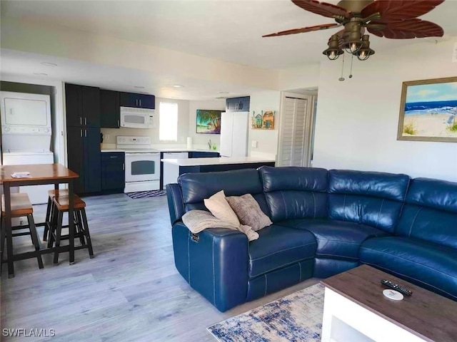 5023 SW 16th Pl Unit 101, Cape Coral, FL 33914 - living room featuring stacked washer and clothes dryer, light wood-style flooring, and a ceiling fan