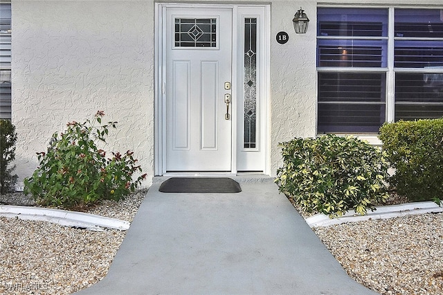 doorway to property featuring stucco siding