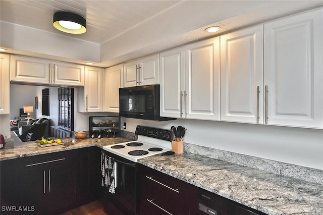 kitchen featuring white cabinets, range with electric stovetop, and light stone countertops