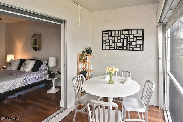 dining space featuring wood finished floors and a textured wall