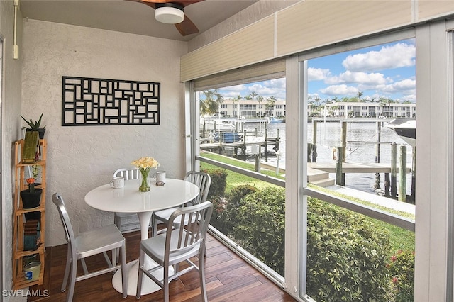 sunroom / solarium featuring ceiling fan, a water view, and a wealth of natural light