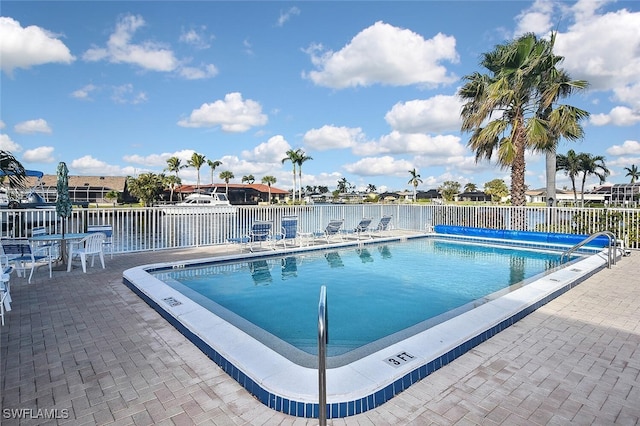 view of swimming pool with a patio and a water view