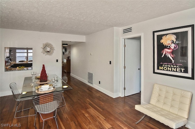 dining area featuring a textured ceiling and dark hardwood / wood-style flooring