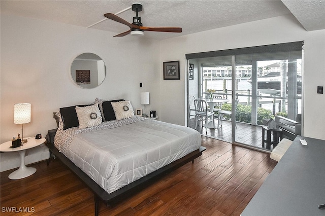 bedroom featuring dark hardwood / wood-style flooring, a textured ceiling, and ceiling fan