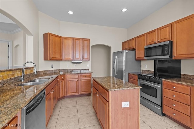 kitchen featuring a center island, crown molding, sink, dark stone countertops, and stainless steel appliances