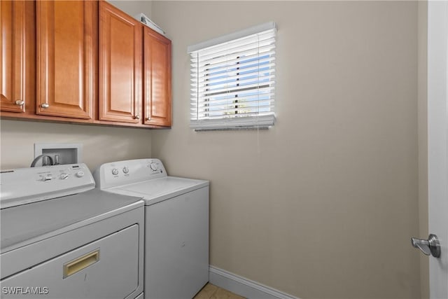 clothes washing area featuring washer and dryer and cabinets