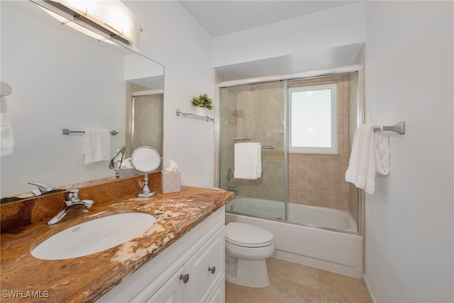 full bathroom with shower / bath combination with glass door, tile patterned floors, vanity, and toilet