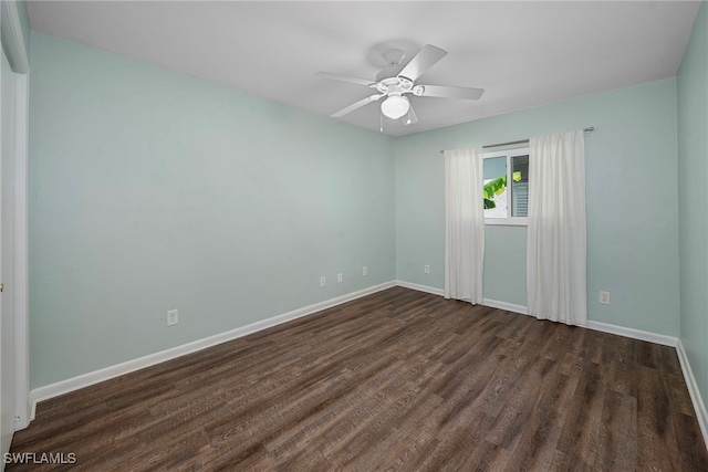 spare room with ceiling fan and dark wood-type flooring