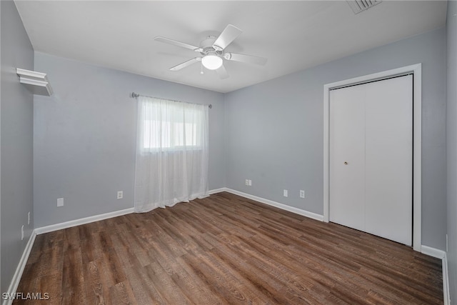 unfurnished bedroom featuring ceiling fan, dark hardwood / wood-style floors, and a closet