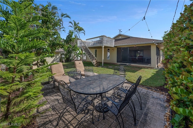 view of patio / terrace featuring stairs, outdoor dining space, and a wooden deck