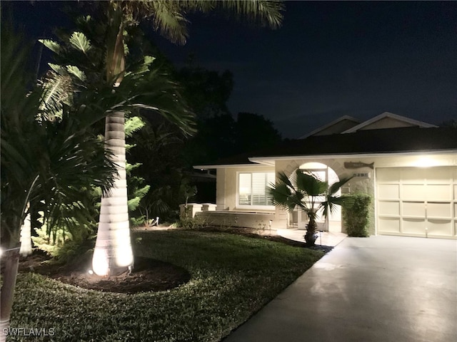 view of front of house featuring a garage, a lawn, and driveway