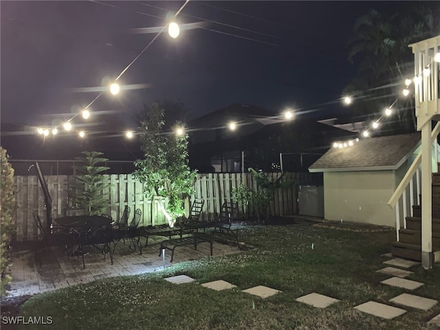 yard at night with a patio area