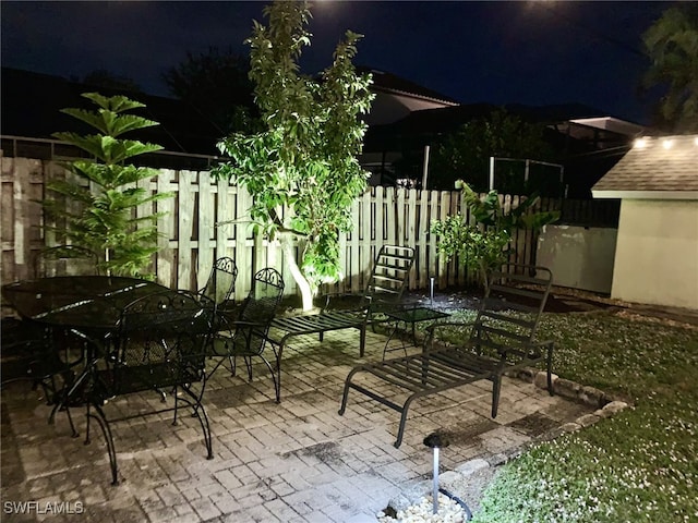 patio at twilight featuring fence