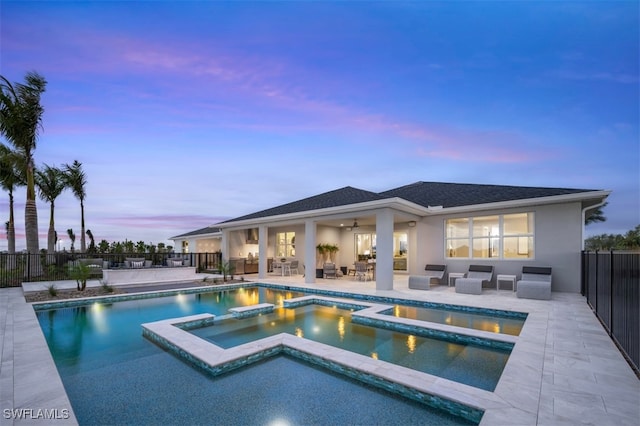 view of swimming pool featuring a ceiling fan, a patio, fence, a pool with connected hot tub, and outdoor lounge area