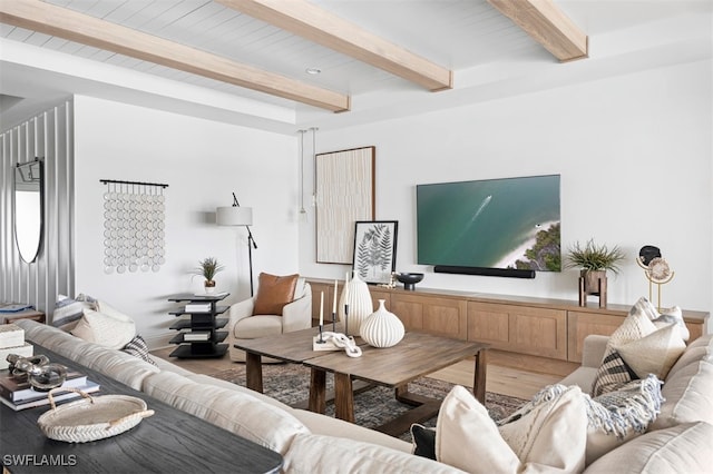 living area featuring beam ceiling and wood finished floors