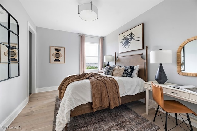 bedroom with baseboards and wood finished floors