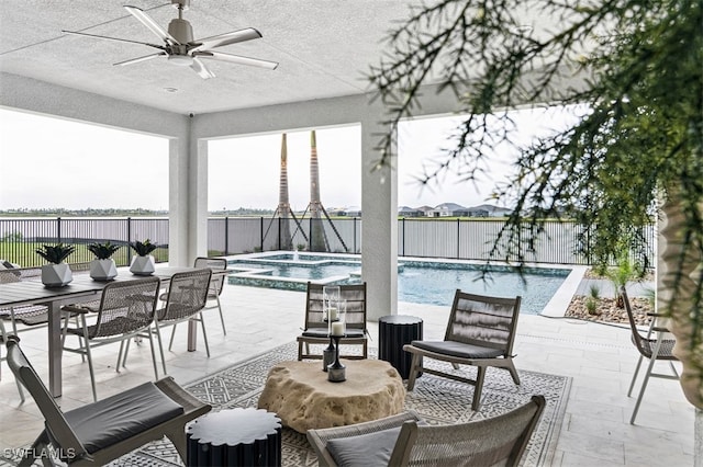 view of patio / terrace with a fenced backyard, a pool with connected hot tub, and a ceiling fan