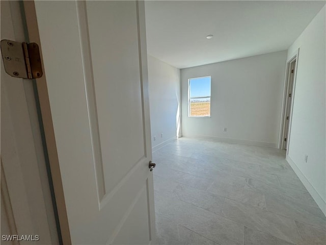 spare room featuring baseboards